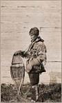 [Anishinaabe man, Laxdywar Nimar, dressed in fur hat, fringed hide jacket, mittens, and floral beaded leggings. He is holding snowshoes] [ca. 1916]