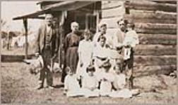 [Family of Chief David John in front of a log cabin] 1918