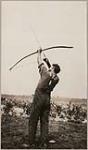 [John Jamieson Jr. shooting a bow] [between 1910-1921]