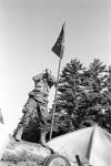 A warrior standing beside a flag on top of the barricade at Kahnesatake 28-29 August 1990