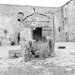 Filling water cans from 13th Century well at castle at Castel Lagopesole. Cpl. J. Pearson and Pte. J. Milligan, both PPCLI 1943