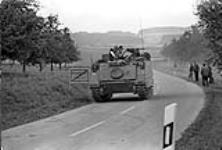 Fallex 77. A Cdn. APC is pictured on a typical German secondary road during Ex. Carbon Edge. As was the case the move was watched with great interest by German civilians 27 September 1977.