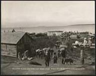 [Men carrying trade goods from shore of Tu Cho (Great Slave Lake) at Deninu K'ue (Fort Resolution)]. Original title: Great Slave Lake from Fort Resolution [ca. 1901].