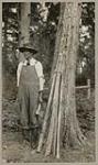 [Anishinaabe man with rough strips of wood for making snowshoes] 1920