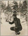 [Man with a grey jay bird at Assiwaban River, Labrador] [between 1921-1922]