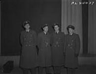 Four RCAF officers photographed outside Buckingham Palace after a recent investiture at which all had received the Distinguished Flying Medal. Awarded their decorations as Sergeants, they have all since then been commissioned. Left to right - P/O J.W. Betty, F/O J. Greenshields, F/O G.R. Price and P/O J.J.N. Rivard. 20 March 1944.