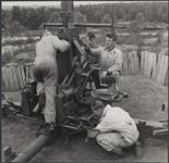 Une equipe d'artilleurs canadien-francais en Angleterre procede au nettoyage d'un canon de d.c.a. De gauche a droite ; les canonniers Edouard Goulet, de Quebec, Edgar Godin, de Tracadie, Leandre Goulet, de Richmond et Leo Bolanger, de Montmagny 4 juin 1943.