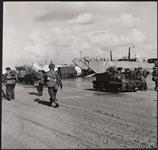 Canadian equipment and methods have been tested again, in a recent amphibious exercise, and lessons learned during the Sicily and Italy landings were applied. Here, on a sandy English beach, tanks and vehicles come off landing craft during the final phase of the exercise 14 October 1943