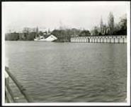 [Shot of the W. J. Henry canoe and boat rental shop, as well as showing a storage wing for Ottawa's Motor Boat Club (OMBC) on the right, located across from Lansdowne Park] circa 1927-1930.