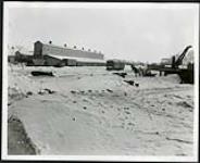[Railyard near Rideau River with buildings, boxcars, and machinery] [1927-1932].