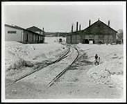 [Split railroad tracks and several buildings surrounding them in background] [1927-1932].