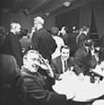 [Men around table at party] [graphic material] [ca. 1970]