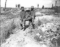 Two very young prisoners carrying wounded Canadian. Advance East of Arras August, 1918.