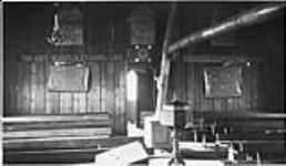 The interior of Anglican Church at Fort Churchill, [Man.] Oct. 19, 1929. (Baptizing stool in the middle, placards with Cree letters on wall 19 Oct. 1929