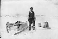 (Hudson Strait Expedition) Robert Anakatok icing komatik, Port Burwell, N.W.T. [Nunavut], March 1928 March 1928.