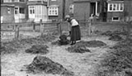 Edna [Boyd] spreading manure in the garden, 3 April, 1917 April 3, 1917.