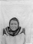 Young Inuk wearing a headscarf and parka seated on a chair, Hebron, Labrador September 1926.