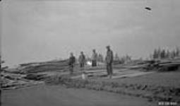 Rev. Canon Hester unloading lumber for Church of England Mission at Aklavik 1925