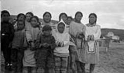 Native boys and girls. Photo includes Letia Kyak, Atagutiak, Panikpak, Panipakouchoo, Enooya, Koman Gapik, and Enooya Enook. [Back row, left to right: Tagurnaaq, Inuujaq Inuk, Inuujakuluk, Inuguk Panikpa, Liitia Panikpakuttuk, Liitia Qajaaq and Ataguttiaq.  Front row, left to right: Piungittuq, Nasuk, Qaumajuq, Kunnakuluk and  Kunualuk.] 4 Septembre 1936