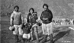 Famille Eskimo [Inuit], Dundas Harbour, le nord de l'Île de Devon, Août 1925. [De gauche à droite : Nukappiannguaq, un garçon inconnu, Inalunnguaq et Tauttianguaq. Ils venaient du Groenland et travaillaient pour la Gendarmerie royale du Canada (GRC).] Août 1925.