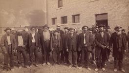 Photographie d'un groupe de prisonniers métis et autochtones de la rébellion du Nord-Ouest [La plupart des hommes nommés dans le dossier] août 1885.
