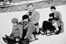 Mr. and Mrs. Georges Vanier with children on sleighs ca. 1930