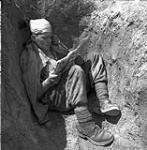 [Private G.U.I. L mbert,B2nd nd Battalion Royal 22e Regiment, reads comic book in slit trench, Korea, 28 May, 1951.]