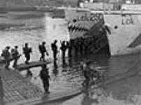 Troops of the Highland Light Infantry of Canada going aboard an L.C.I.(L) at dawn 4 juin 1944.