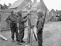 "Stop, Enemy Ahead" sign being erected by personnel of No. 4 Provost Company, Bretteville-le-Rabet, France, 23 June 1944 June 23, 1944.