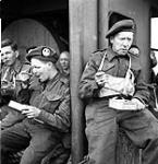 Canadian infantrymen from various units, including The Cameron Highlanders of Ottawa (M.G.), eating a meal aboard ship en route to the Normandy beachhead, France, 6 June 1944 June 6, 1944.