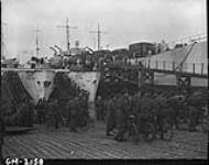 Troops of the Highland Light Infantry of Canada (Kitchener, Galt) going aboard a Canadian L.C.I.(L.) at dawn 7 June 1944