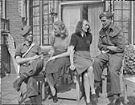 Pte. H.A. Wilson and L/Cpl. J. Semrick visiting the Arnhem twins, Gerda Warko and Helen Sensburg of the Mary Arnhem program 18 May 1945
