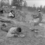 During the cattle drive to Quesnel, B.C., Mrs. Phillips sets up the camp ahead each day, because the wagon moves faster than cattle. Here the Phillips family eats supper. The wagon is seen at left in the background Oct. 1956
