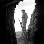 Gunner Douglas Hat on guard outside the Battery Command Post of the 17th Field Regiment, Royal Canadian Artillery (R.C.A.), Castel Frentano, Italy, 10 February 1944 February 10, 1944.