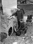 Cookstove built by signals personnel of the 5th Canadian Armoured Division. (Left to right): Cpl.G.I. Graham, Sig. j.Le Blanc. Castelnuovo, Italy, 17 March 1944 17 Mar. 1944