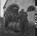 Black Watch 'B' Company men gathered around a barrel covered well, L. to r.: Ptes. Phil Chenier, Norman Yocco, Johnny Koropchuk, Dave Johnstone, Albert Bagg and Ed Newbury. Groesbeek, Netherlands, 3 Feb. 1945 3 FEB. 1945