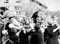 Private H.A. Woodruff of The Stormont, Dundas and Glengarry Highlanders distributing candy to Dutch civilians, Bathmen, Netherlands, 9 April 1945 April 9, 1945.