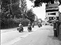 Vehicles and motorcycles of Les Fusiliers Mont-Royal moving through Leer, Germany, 11 July 1945 July 11, 1945.