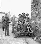 Personnel of the Canadian Army Film and Photo Unit with their jeep, Gruchy, France, 9 July 1944 July 9, 1944.