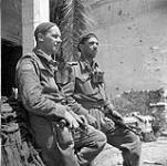 Lieutenant W. Smith, a platoon commander, and Sergeant F.G. White, a platoon sergeant, both of The Royal Canadian Regiment, resting after the capture of Pontecorvo, Italy, 24 May 1944 May 24, 1944.