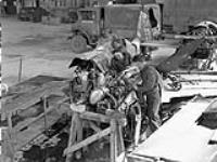 Personnel of the 7th Infantry Brigade Workshop, Royal Canadian Electrical and Mechanical Engineers (R.C.E.M.E.), examining a damaged Focke Wulf Fw 190 aircraft of the Luftwaffe at an airfield between Aurch and Wilhelmshaven, Germany, 8 May 1945 May 8, 1945.
