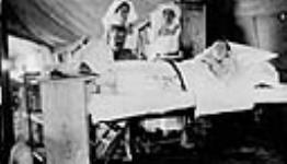 Wounded World War Canadian soldier in No. 2 Hospital, with visitor and attending nurses 1916