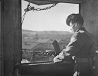 Concentration camp - Private I. C. Pierrie on guard with Bren in one of the four watch towers 30 Ot. 1945