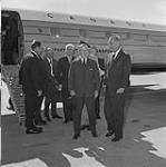Columbia River Treaty Ratification. Prime Minister Lester B. Pearson (centre) with President Lyndon B. Johnson on airport tarmac possibly after air tour of the Columbia River complex 14 - 16 Sept. 1964.