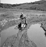 Despatch rider L/Cpl Paul Harvey of Royal 22nd Canadian Regiment with his motorcycle 15 Sept. 1951