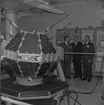 Officials examining the ISIS A satellite at the R.C.A. Victor plant. (L-R): H.B. Godwin, Eric Kierans, J.M. Stewart 1 Aug. 1968