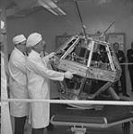 Technicians displaying the ISIS A satellite at the R.C.A. Victor plant 1 Aug. 1968