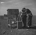 L/Cpl Tom Amstrong giving information at an advanced information post on the highway to Bretville-Sur-Laize to L/Cp John McDonald 9 Aug. 1944