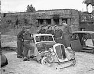 Personnel of the Canadian Berlin Battalion examining a wrecked automobile, Berlin, Germany, 9 July 1945 09-Jul-45
