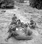 Troopers of the 12th Manitoba Dragoons playing cards near Caen, France, 19 July 1944 July 19, 1944.